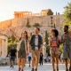Ομάδα τουριστών απολαμβάνει μια περιήγηση με τα πόδια στον πεζόδρομο κάτω από την Ακρόπολη στην Αθήνα.